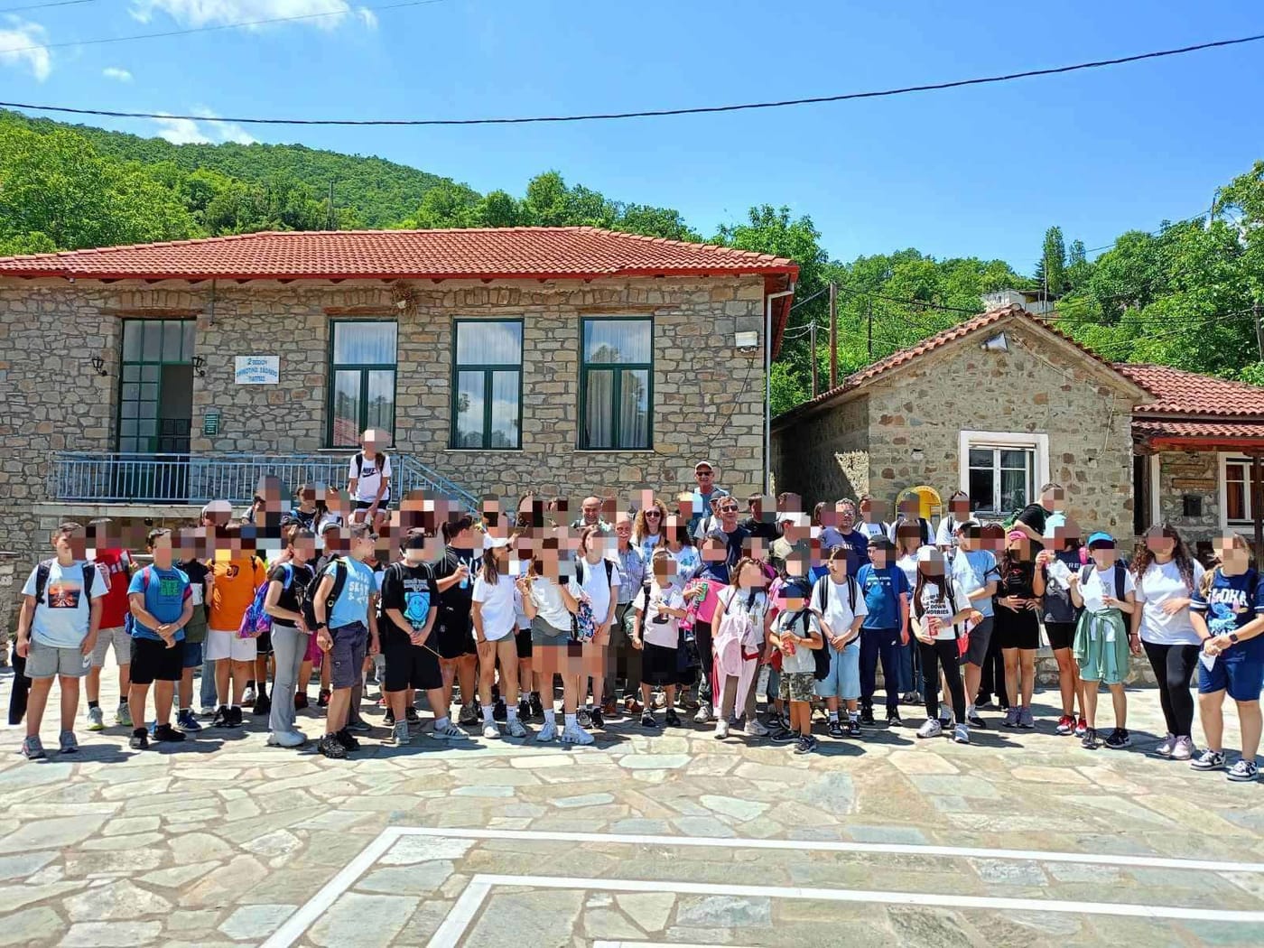 ομαδική φωτογραφία μπροστά στο πέτρινο σχολείο